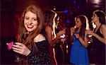 Pretty redhead drinking a cocktail at the nightclub