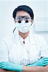 Portrait of female dentist wearing surgical mask and dental loupes