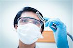 Portrait of female dentist in surgical mask holding dental drill