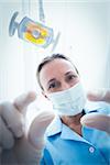 Low angle portrait of female dentist in surgical mask