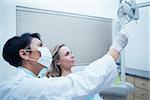 Side view of female dentist showing woman her mouth x-ray