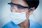 Close up of female dentist wearing surgical mask and safety glasses