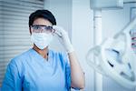 Portrait of female dentist wearing surgical mask and safety glasses