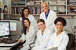 Science students smiling at camera with professor at the university