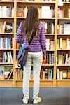 University student standing in the bookcase at the university