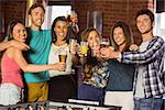 Portrait of happy friends toasting with mixed drink and beer in a bar