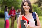 Pretty student smiling at camera outside on campus at the university