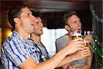 Happy friends toasting with pints of beer on patricks day in a bar