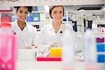 Pretty science students using pipette at the university