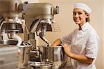 Baker using large mixer to mix dough in a commercial kitchen