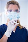 Dentist in mask and glove holding an injection at the dental clinic