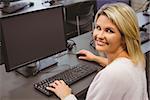 Mature student in computer room smiling at camera in the campus