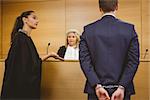 Lawyer talking with the criminal in handcuffs in the court room