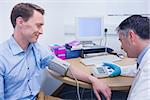 Doctor measuring his patients blood pressure at the hospital