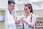 Pharmacist giving paper bag to his customer in the pharmacy