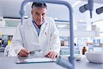 Smiling biochemist preparing some medicine in laboratory