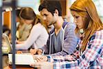 Four focused classmates working together in library