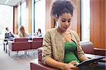 Attractive serious student using tablet at the university