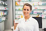 Junior pharmacist showing medicine box at the hospital pharmacy