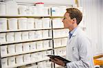 Handsome pharmacist looking at medicine at the hospital pharmacy