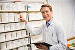 Handsome pharmacist taking medicine from shelf at the hospital pharmacy