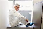 Pharmacist putting on his shoe covers at the laboratory