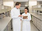 Team of pharmacists looking at clipboard at the laboratory