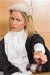 Stern judge pointing her hammer in the court room