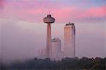 Mist from Horseshoe Falls swirling in front of Skylon Tower at dawn, Niagara Falls, Niagara, border of New York State and Ontario, Canada, North America