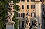 Angel statues on Ponte Sant' Angelo with grand house behind, Rome, Lazio, Italy, Europe