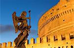 Angel statue on Ponte Sant' Angelo bridge at dusk with Castel Sant' Angelo, Rome, Lazio, Italy, Europe