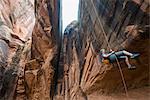 Woman rapelling down a giant arch, canyoneering, Moab, Utah, United States of America, North America