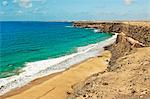 Volcanic rock headland and sandy beach south of this village on the north west coast, El Cotillo, Fuerteventura, Canary Islands, Spain, Atlantic, Europe