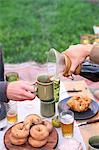 An apple orchard in Utah. Two people sitting at a table with food and drink, pouring coffee.