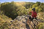 Man on bicycle taking a water break while mountain biking through Ballard Park in Newport, Rhode Island, USA