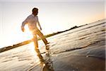 Man skipping rocks in the water at Bailey's Beach on an autumn morning, Newport, Rhode Island, USA