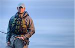 Portrait of a man while fishing on the rocks along the coast of Rhode Island, USA