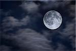 A full Moon revealed through clouds, USA