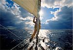 Man adjusting the jib while sailing offshore on the Atlantic Ocean.