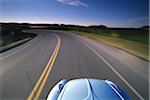 A 1974 VW Beetle drives along Ocean Avenue in Newport, Rhode Island, USA.