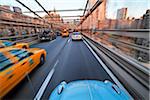 Driving over the Brooklyn Bridge in a VW Beetle towards Manhattan, New York City, New York, USA.