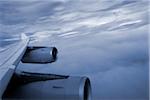 Close-up of the wing and engines of a jet while flying in the clouds