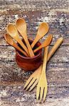 Arrangement of Small Wooden Spoons in Pot and Wooden Forks isolated on Rustic Wooden background