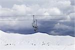 Chair lifts and off-piste slope at gray day. Caucasus Mountains, Georgia. Ski resort Gudauri.