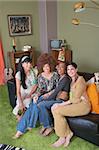 Group of four hippies sitting on leather sofa