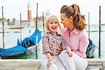 Portrait of happy mother and baby on grand canal embankment in venice, italy