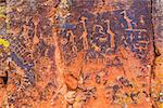 Multiple Sinaguan petroglyphs on a red rock panel