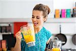 Fitness young woman with pumpkin smoothie in kitchen
