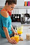 Fitness young woman with glass of pumpkin smoothie in modern kitchen