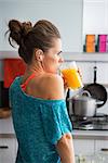 Portrait of fitness young woman drinking pumpkin smoothie in kitchen